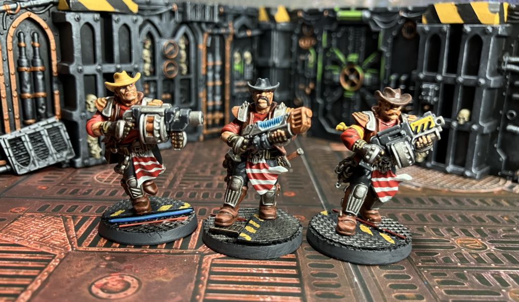 Three Orlock champions, one with a grenade launcher, one with a plasma gun, one with a bolter