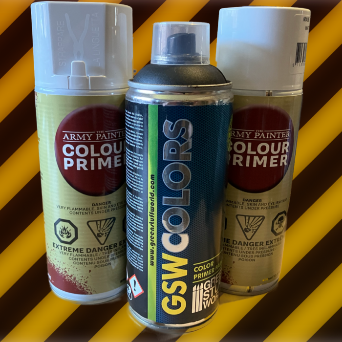 Two cans of Army Painter and a can of Green Stuff World primer on a hazard stripe background.