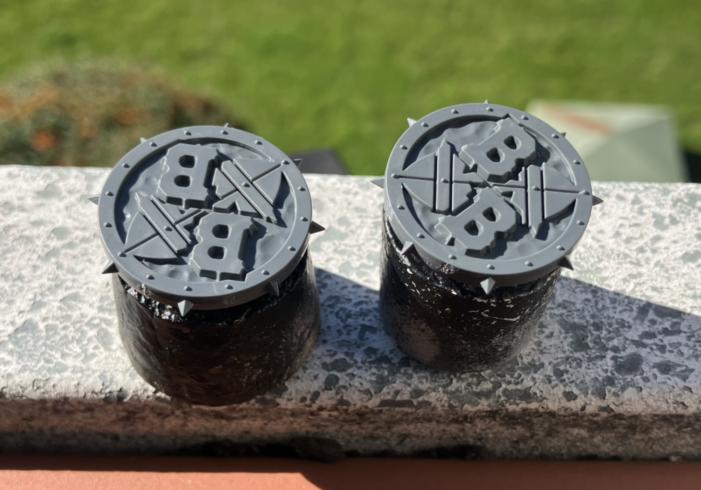 Two naked Blood Bowl coins on corks to be primed.