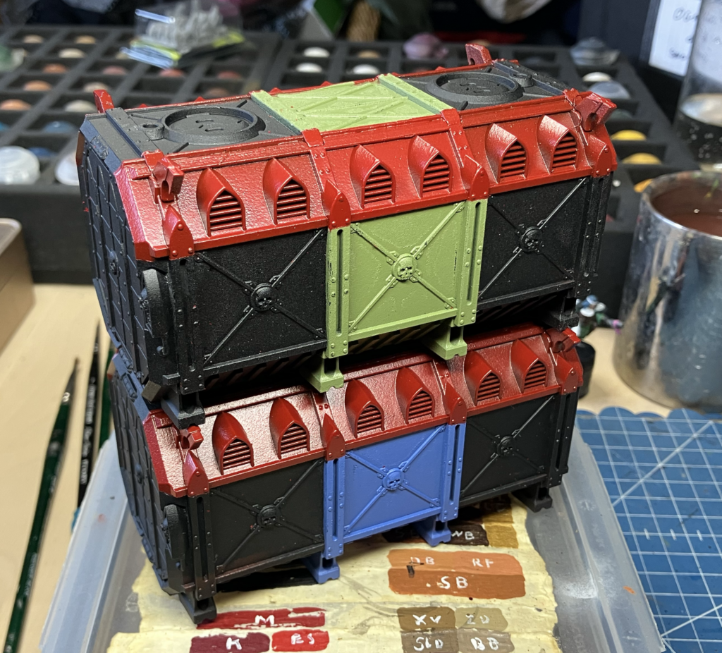 Two Munitorum Containers after being masked and painted with a rattle can.