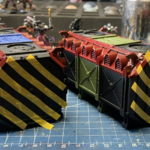 Two Munitorum Containers masked off for hazard stripes